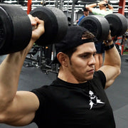 Man wearing black BBPM Flex Athletic T-Shirt shoulder pressing